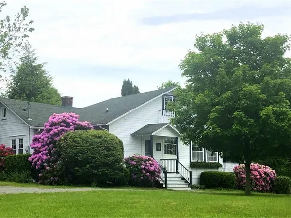 a backyard of a house with a yard and outdoor seating