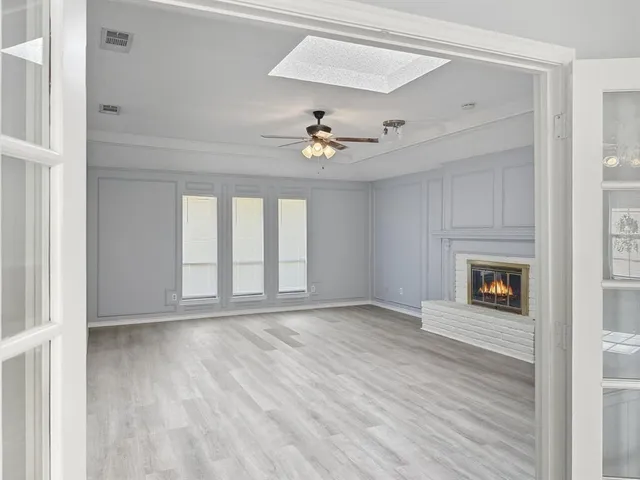 a view of an empty room window and wooden floor