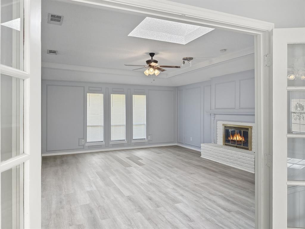 a view of an empty room window and wooden floor