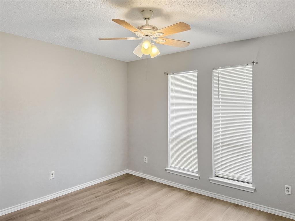 2308 Winterstone Drive Plano, TX 75023 - Photo 14 of 16 an empty room with wooden floor fan and windows