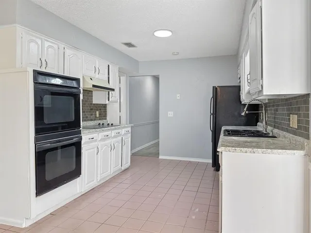 a kitchen with stainless steel appliances granite countertop a stove a refrigerator and a cabinets