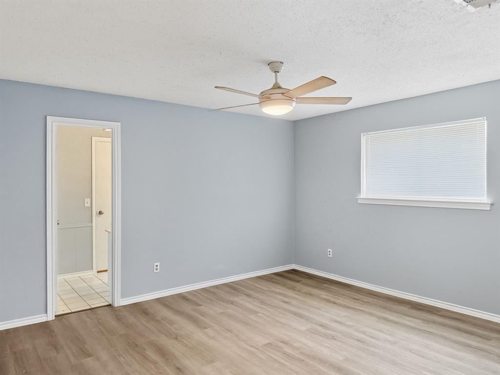 2308 Winterstone Drive Plano, TX 75023 - Photo 8 of 16 a view of an empty room with wooden floor and a ceiling fan