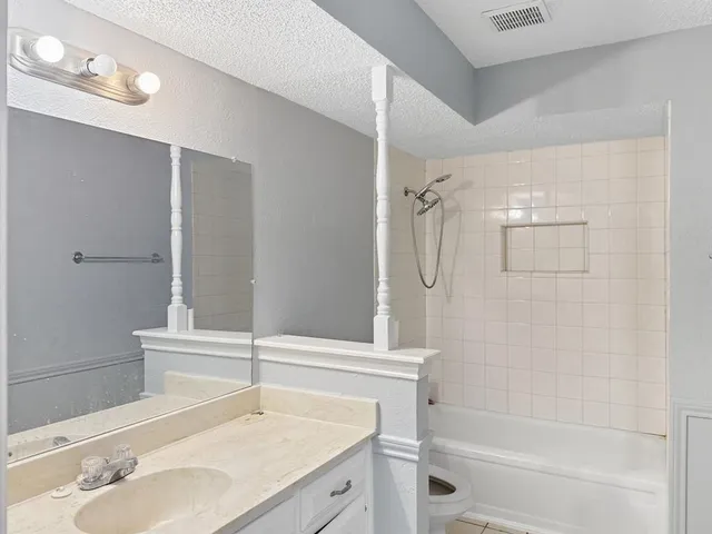 a bathroom with a granite countertop sink toilet and shower