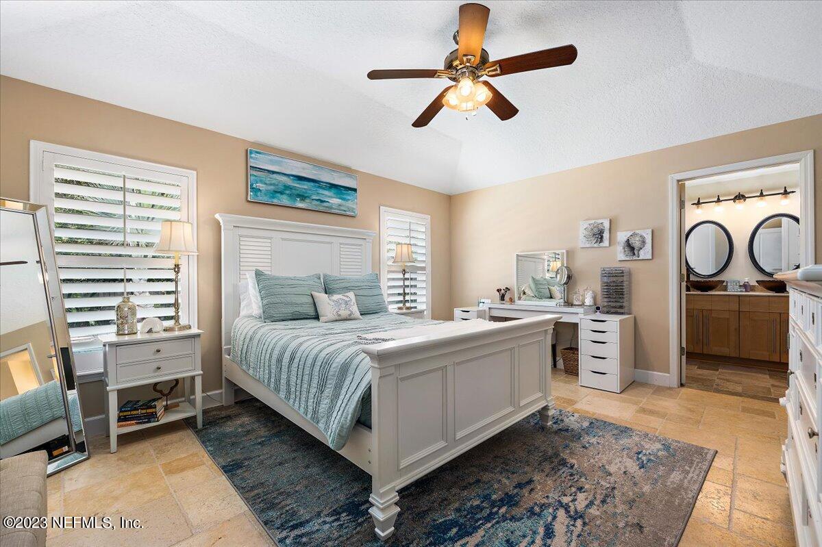 313 Eleventh Street St. Augustine, FL 32084 - Photo 22 of 35 a spacious bedroom with a bed and a chandelier
