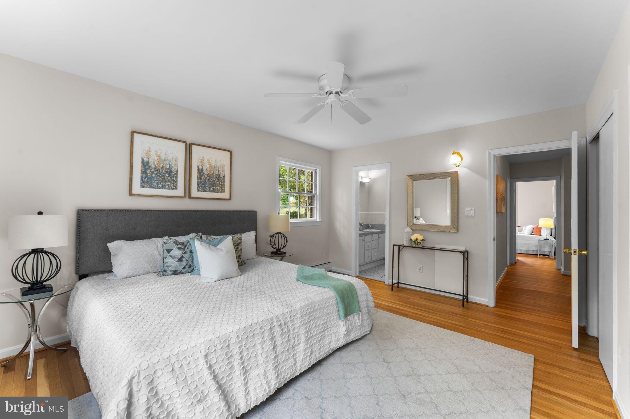 11800 Stoney Creek Road Potomac, MD 20854 - Photo 22 of 78 a spacious bedroom with a bed and a chandelier