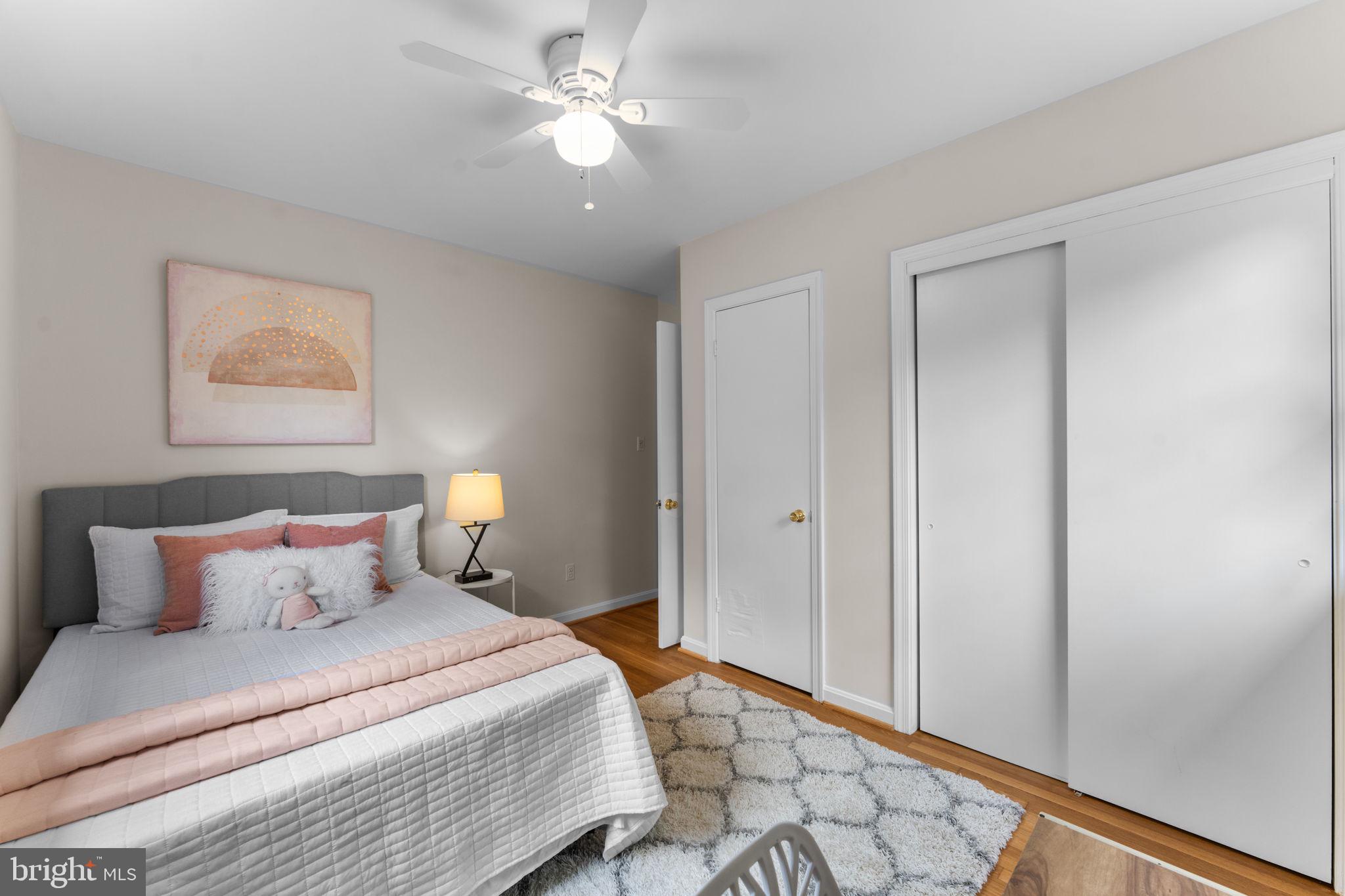 11800 Stoney Creek Road Potomac, MD 20854 - Photo 31 of 78 a bedroom with a large bed and a chandelier