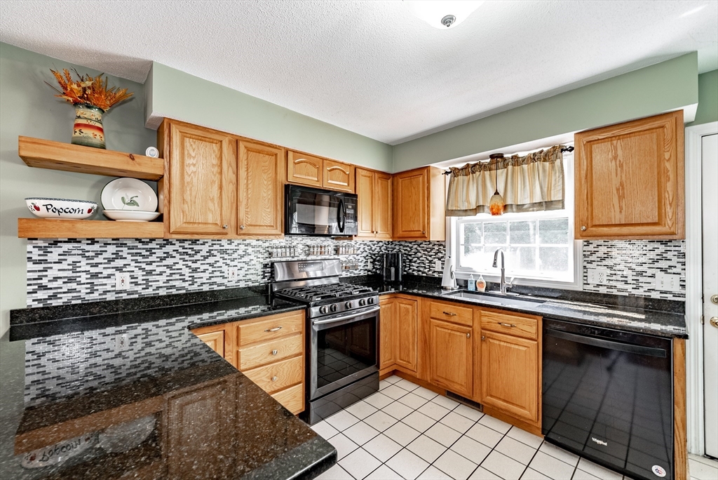 116 Garland Street Springfield, MA 01118 - Photo 12 of 31 a kitchen with stainless steel appliances granite countertop a stove sink and cabinets