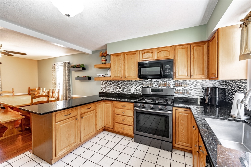 116 Garland Street Springfield, MA 01118 - Photo 10 of 31 a kitchen with stainless steel appliances granite countertop a stove a sink and a microwave
