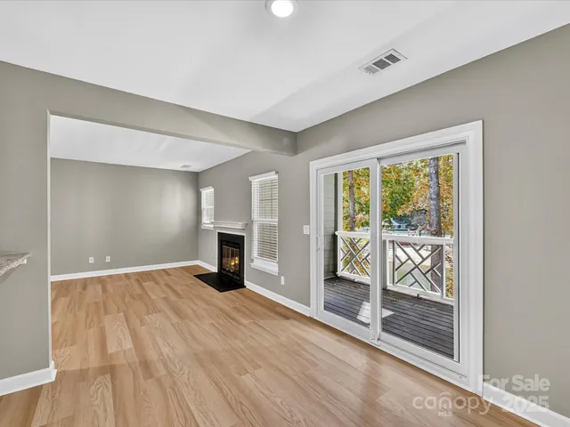 a view of empty room with wooden floor and fireplace
