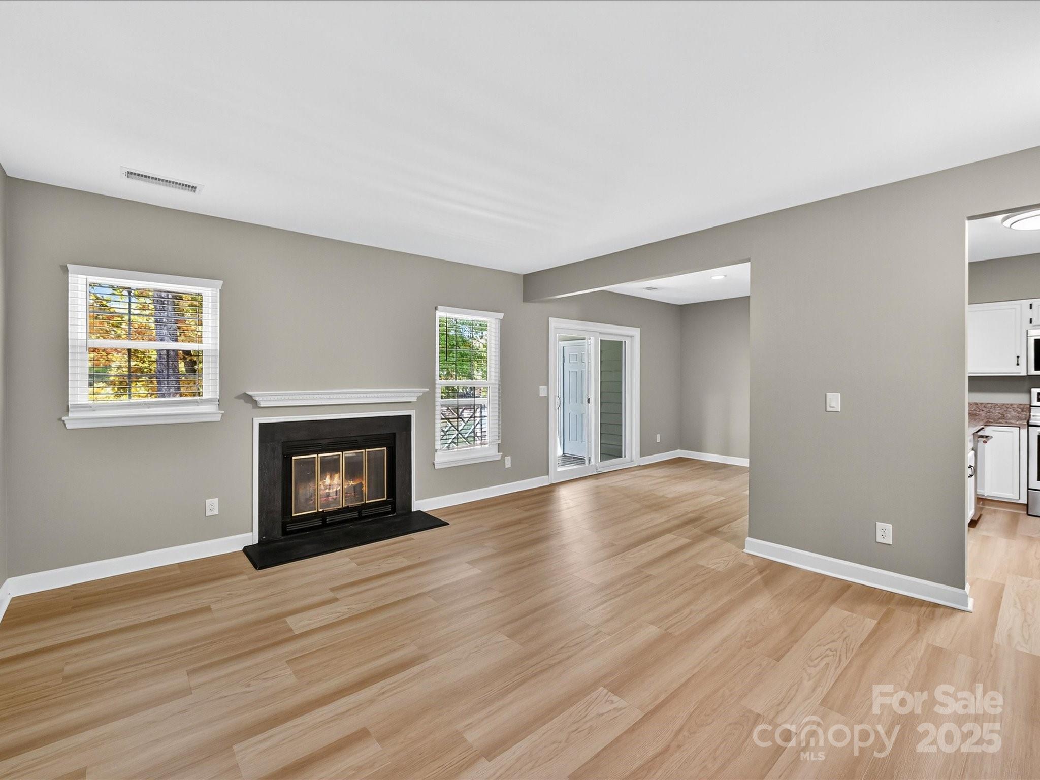 20115 Henderson Road, Unit D Cornelius, NC 28031 - Photo 5 of 44 an empty room with wooden floor fireplace and windows