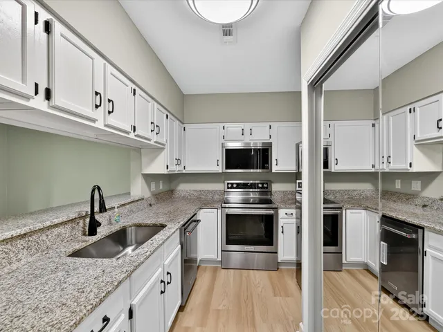 a kitchen with stainless steel appliances granite countertop a sink stove and cabinets
