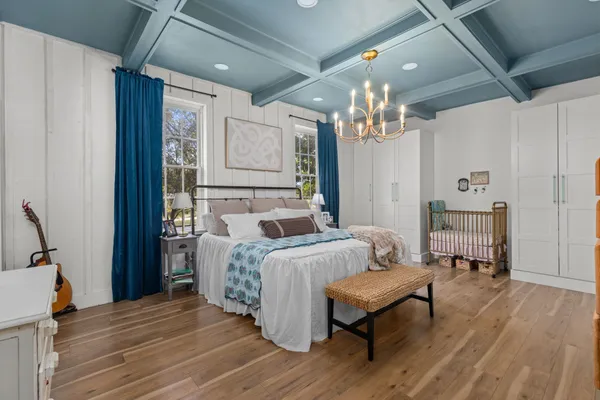 a bedroom with a bed and a chandelier