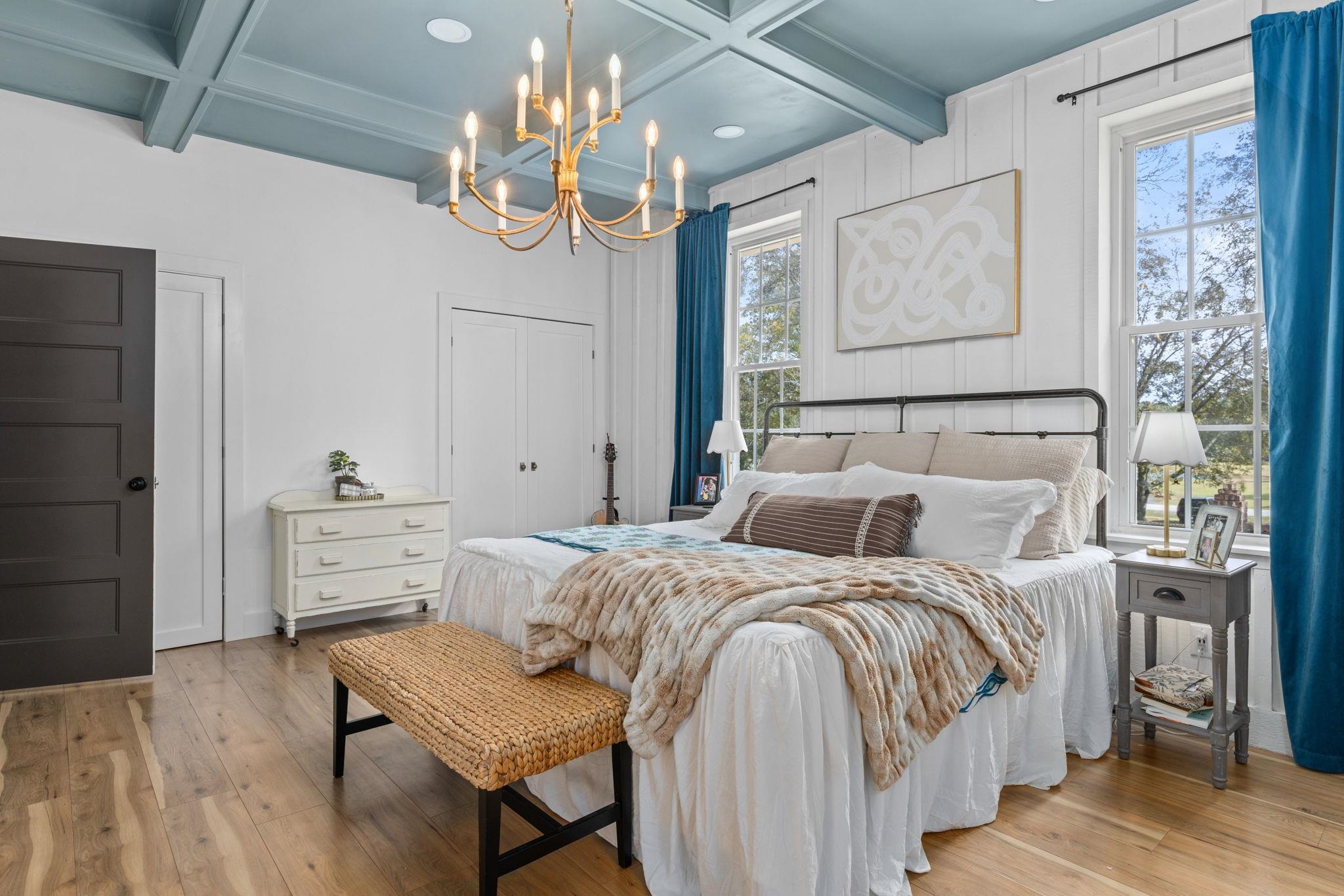 41 County Road 409 Rienzi, MS 38865 - Photo 15 of 40 Bedroom featuring multiple closets, beam ceiling, light wood-type flooring, a chandelier, and coffered ceiling