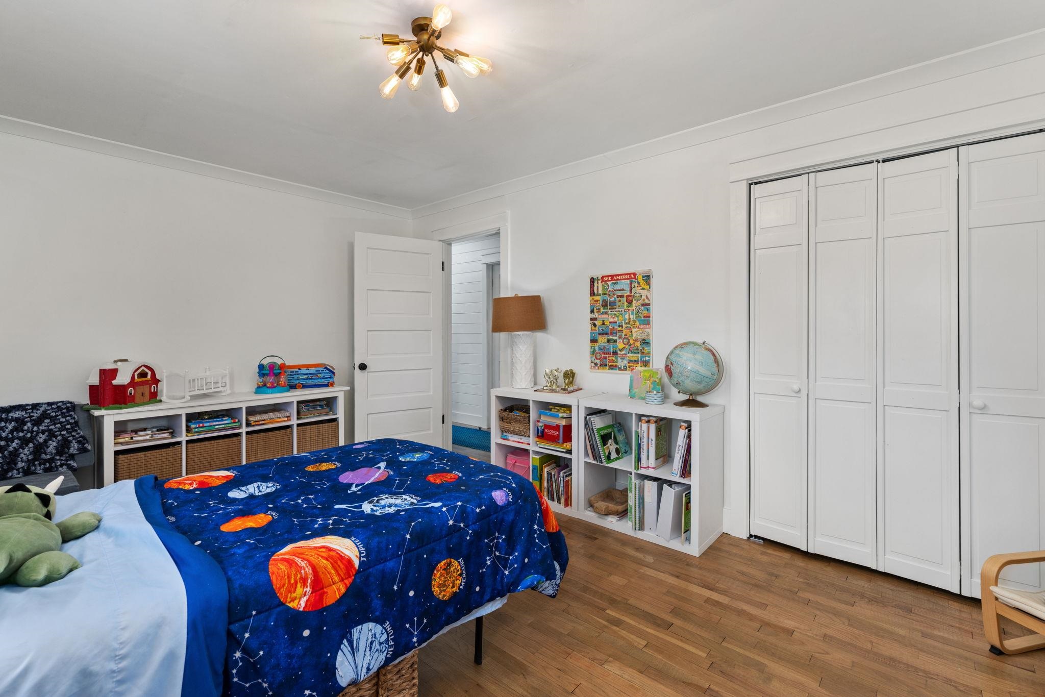 41 County Road 409 Rienzi, MS 38865 - Photo 27 of 40 Bedroom with wood finished floors, a closet, and a chandelier