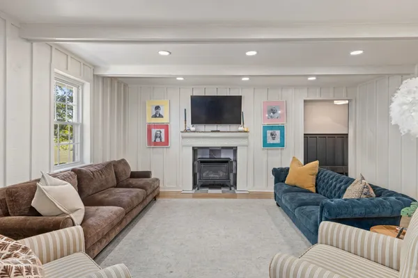 a living room with furniture a flat screen tv and a fireplace