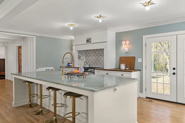 a kitchen with sink a window and chairs