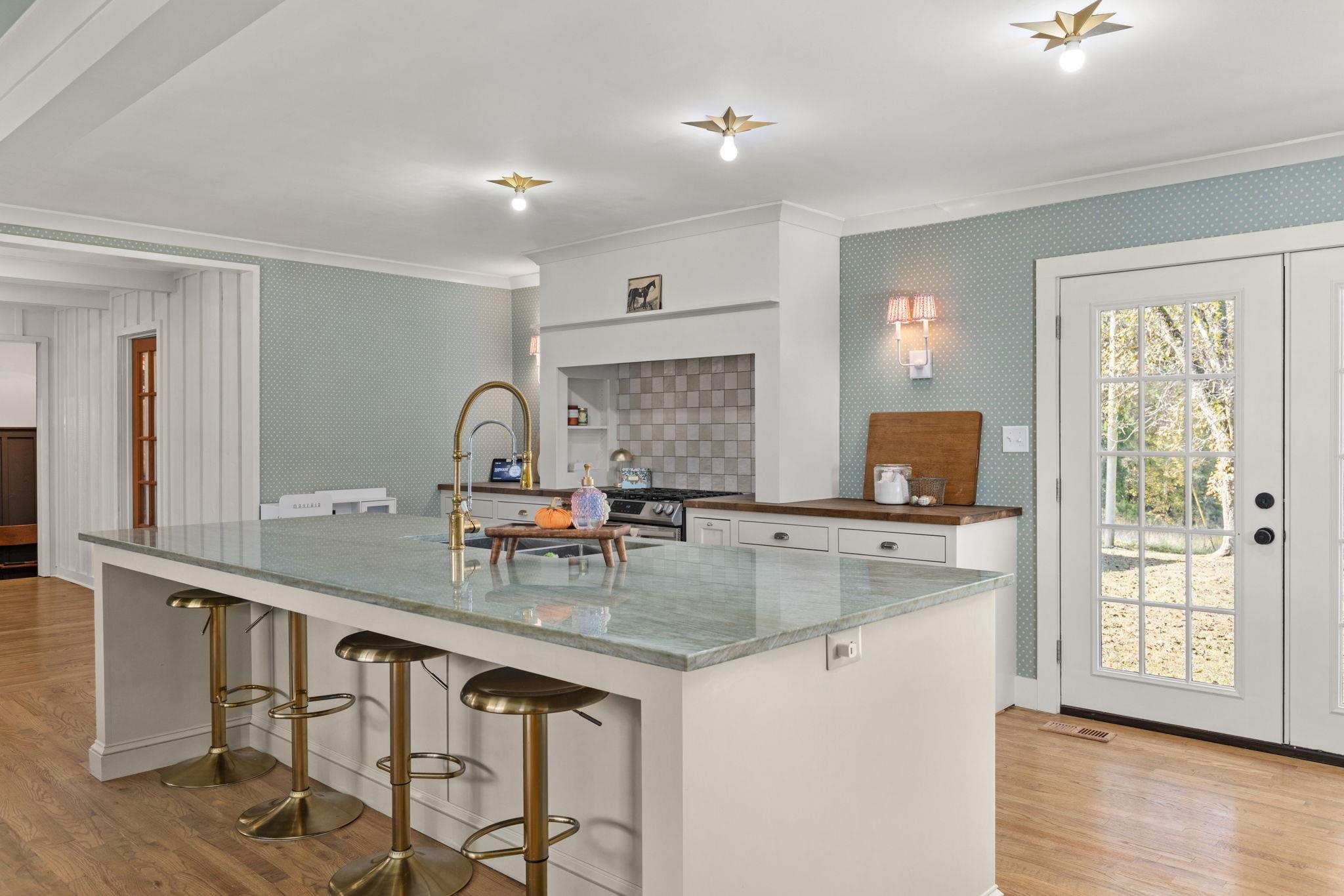 41 County Road 409 Rienzi, MS 38865 - Photo 6 of 40 Kitchen featuring ornamental molding, a kitchen breakfast bar, light wood-style floors, a spacious island, and white cabinetry