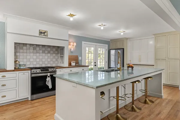 a kitchen with granite countertop stainless steel appliances a sink stove and cabinets