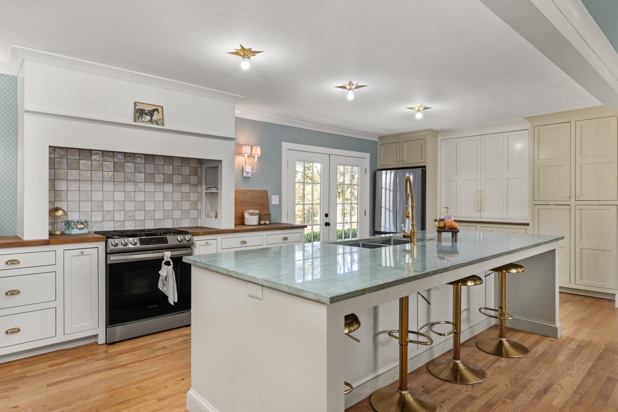 41 County Road 409 Rienzi, MS 38865 - Photo 7 of 40 Kitchen with stainless steel appliances, a breakfast bar, light wood-style floors, a kitchen island with sink, and ornamental molding