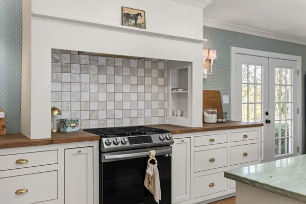 a kitchen with granite countertop white cabinets and white appliances