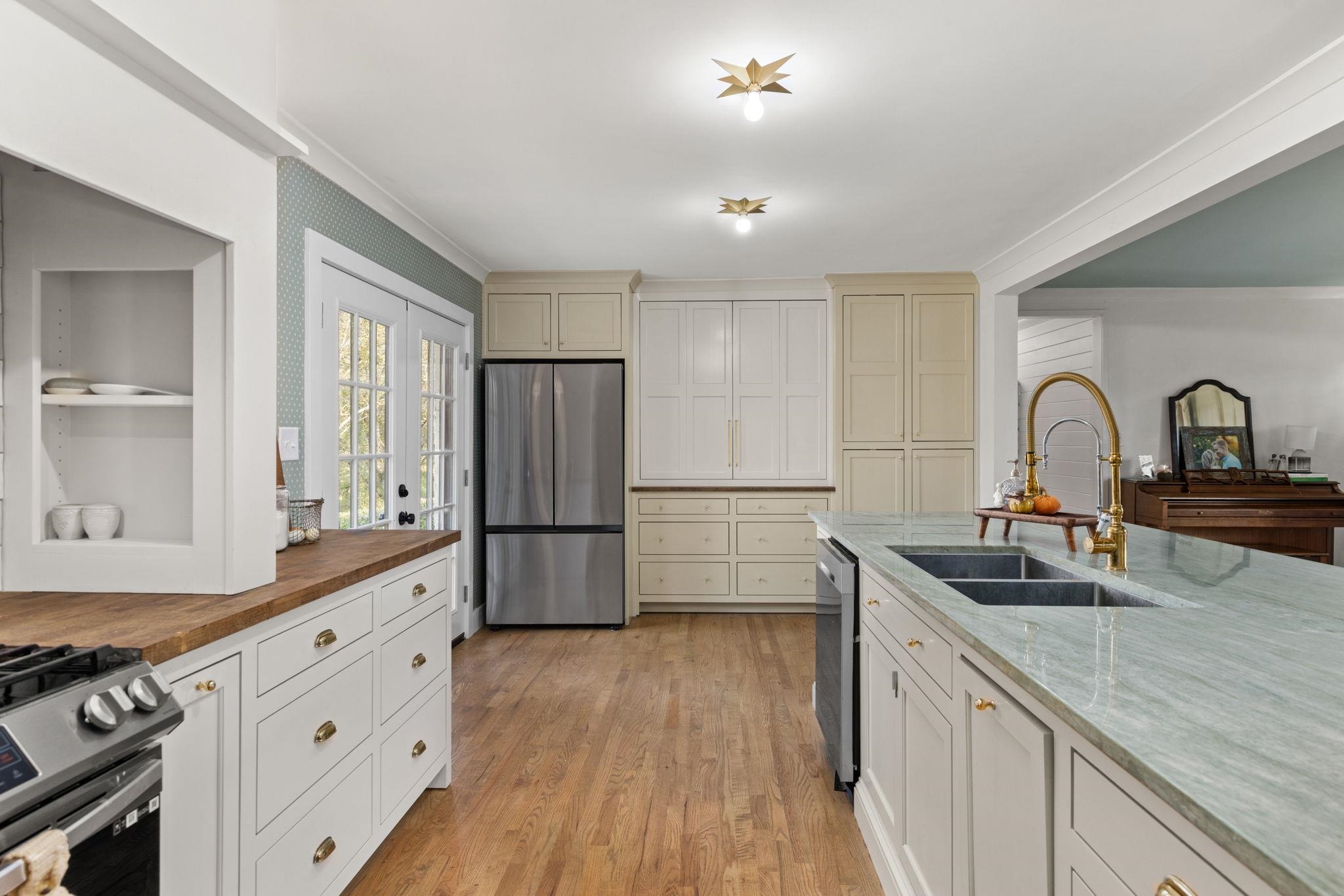 41 County Road 409 Rienzi, MS 38865 - Photo 9 of 40 Kitchen with stainless steel appliances, light wood-style flooring, french doors, crown molding, and light stone countertops