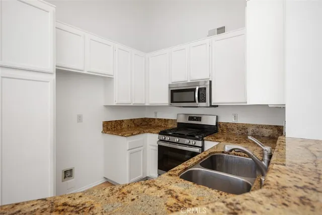 a kitchen with a sink stove and microwave