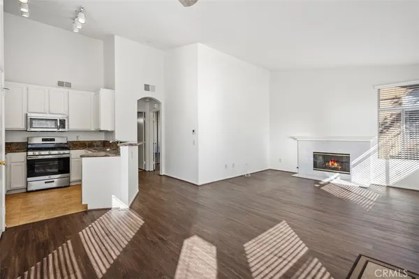 a kitchen with stainless steel appliances granite countertop a stove a sink and a microwave