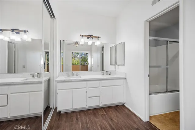 a spacious bathroom with a double vanity sink and mirror