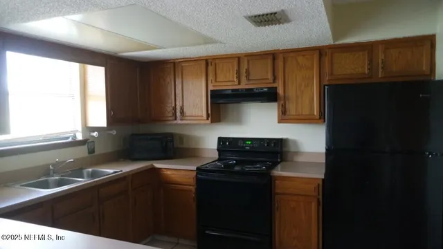 a kitchen with stainless steel appliances granite countertop a sink stove and cabinets