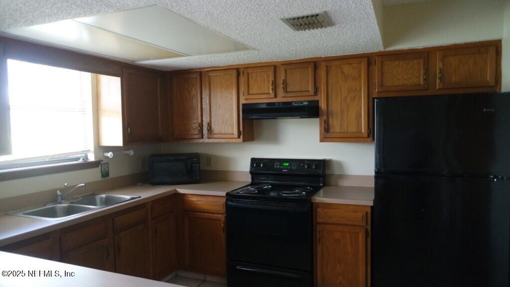 1389 Pawnee Street Orange Park, FL 32065 - Photo 4 of 13 a kitchen with stainless steel appliances granite countertop a sink stove and cabinets