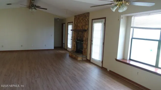 a view of a room with wooden floor and a window