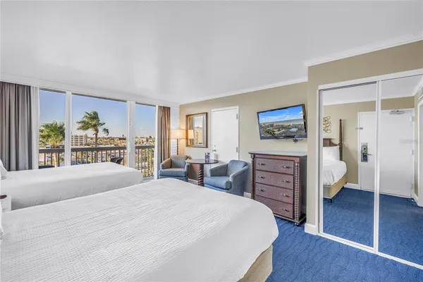 a bedroom with a large bed and a flat tv screen