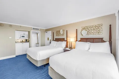 a bedroom with two beds and painting on the wall