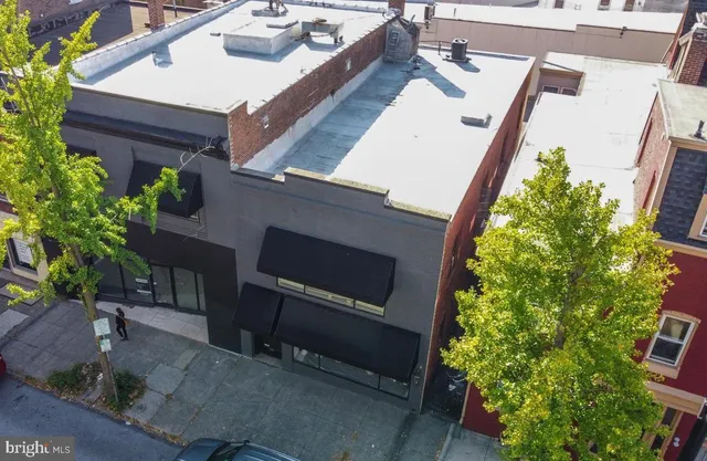 a roof deck with table and potted plants