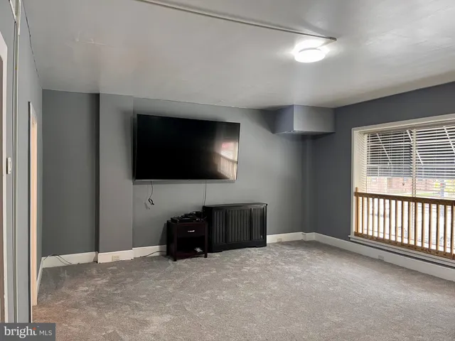a living room with a flat screen tv and a refrigerator