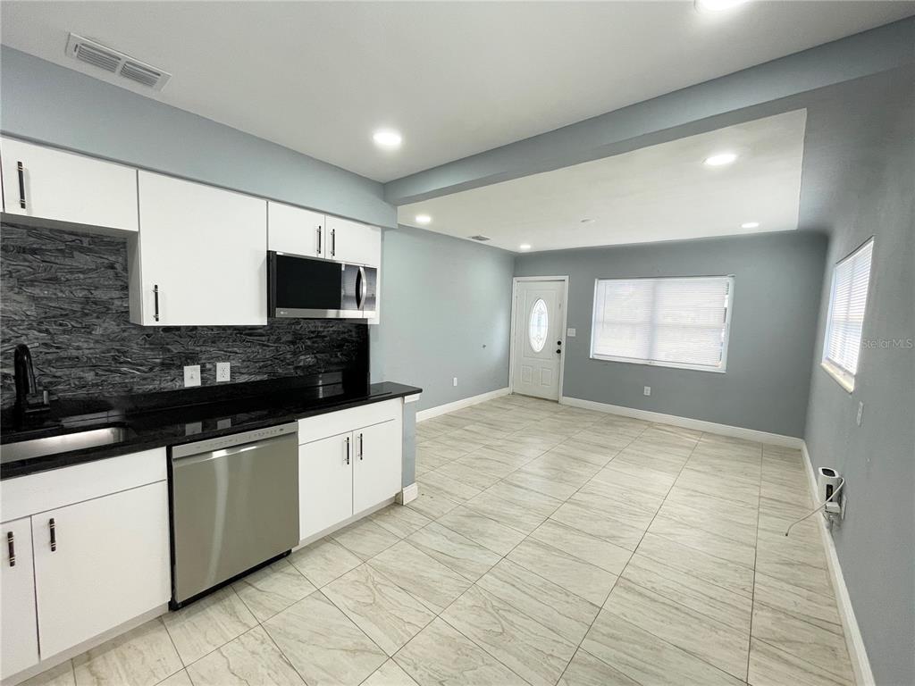 3428 Ithaca Street North St. Petersburg, FL 33713 - Photo 5 of 22 a large kitchen with stainless steel appliances granite countertop a sink and cabinets