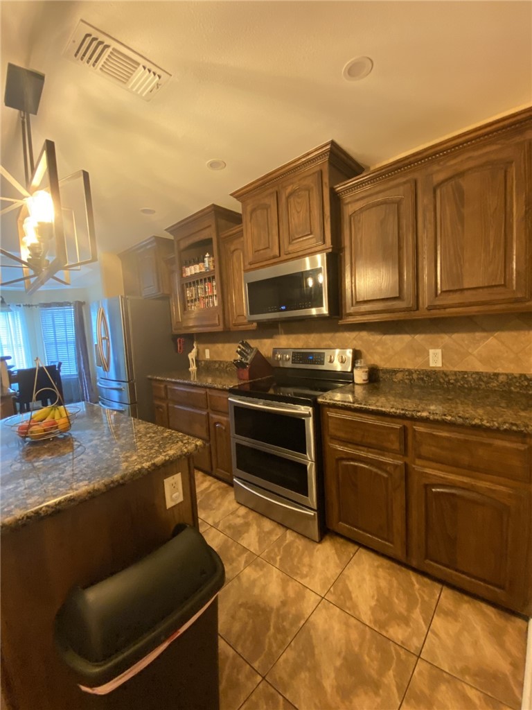 1250 Lawrence Trail Alice, TX 78332 - Photo 14 of 40 a kitchen with stainless steel appliances granite countertop a stove a sink and a microwave