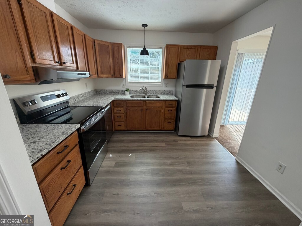 9292 Settlers Grove Road Northeast Covington, GA 30014 - Photo 15 of 110 a kitchen with stainless steel appliances granite countertop a refrigerator stove and a sink