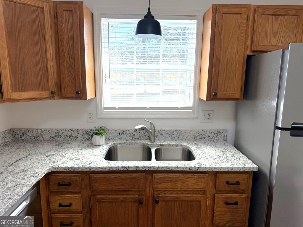 9292 Settlers Grove Road Northeast Covington, GA 30014 - Photo 20 of 110 a kitchen with a sink a refrigerator and cabinets