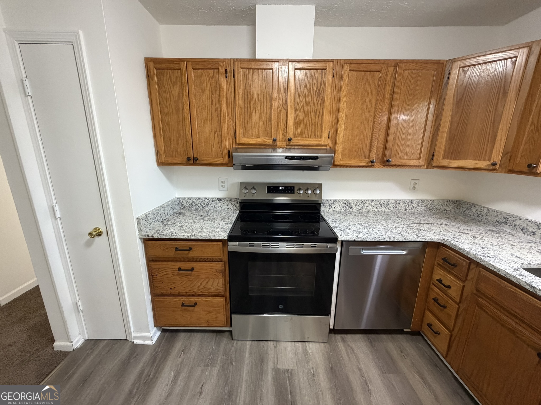 9292 Settlers Grove Road Northeast Covington, GA 30014 - Photo 21 of 110 a kitchen with granite countertop wooden cabinets a sink and dishwasher