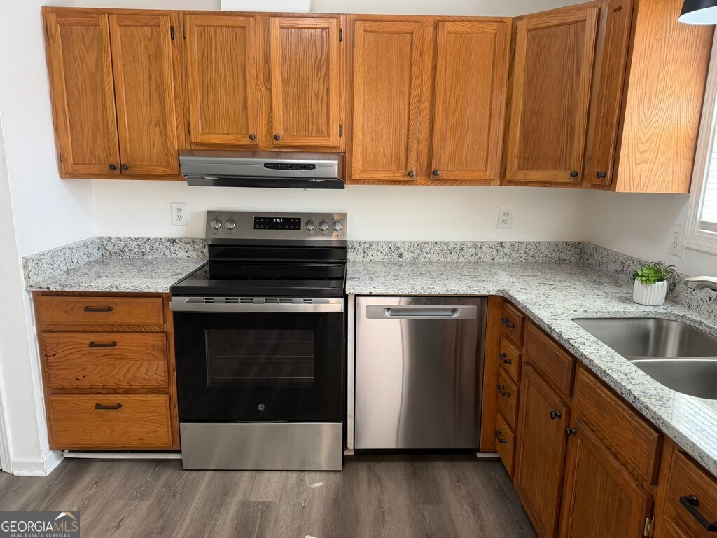 9292 Settlers Grove Road Northeast Covington, GA 30014 - Photo 22 of 110 a kitchen with granite countertop wooden cabinets and white appliances