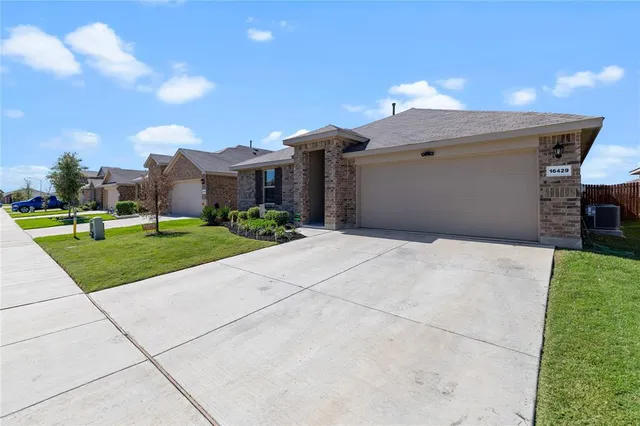 a view of a white house with a yard and potted plants