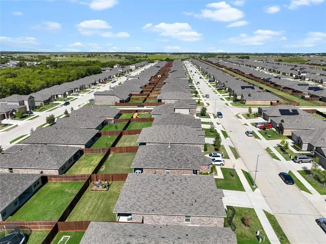 an aerial view of residential houses with yard