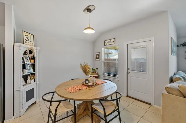 a kitchen with stainless steel appliances a stove a refrigerator a kitchen island a sink a refrigerator white cabinets and chairs