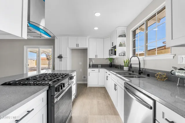 a kitchen with stainless steel appliances a sink a stove and a refrigerator