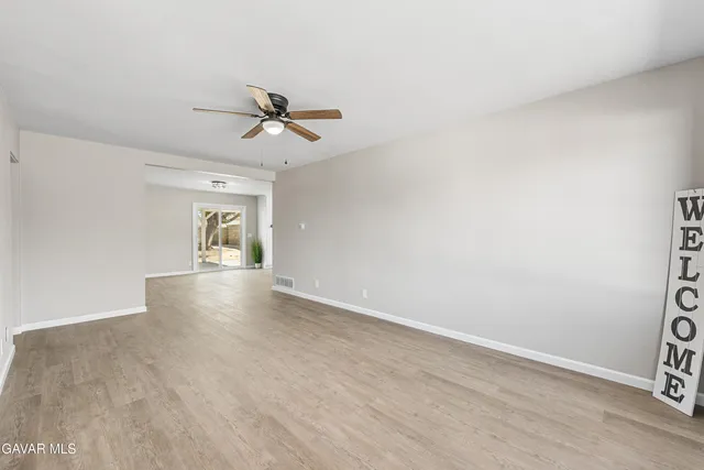 a view of a livingroom with a ceiling fan & hardwood floor