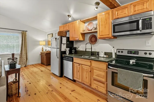 a kitchen with granite countertop a sink a stove and cabinets