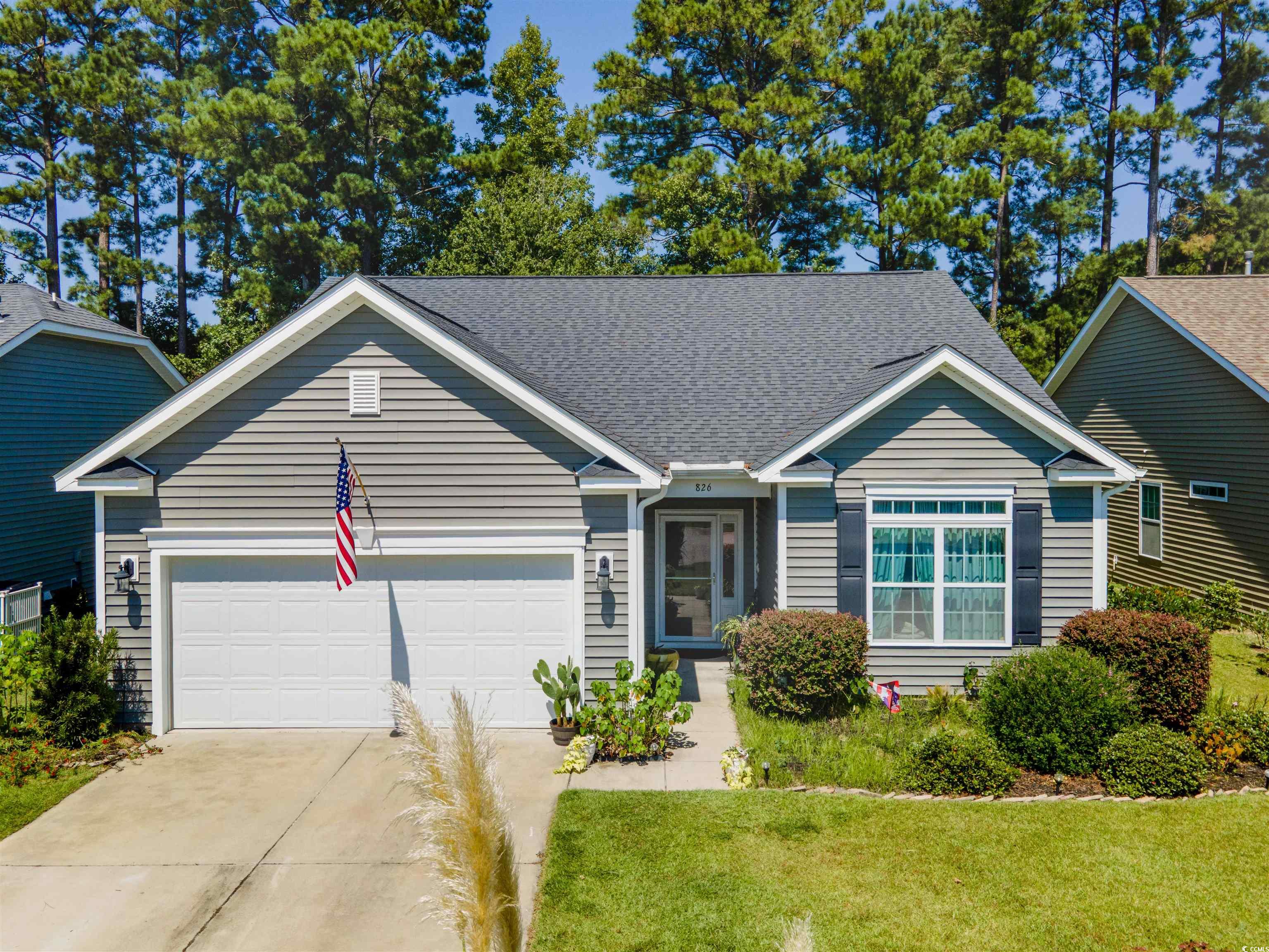 Single story home with concrete driveway, roof with shingles, an attached garage, and a front yard