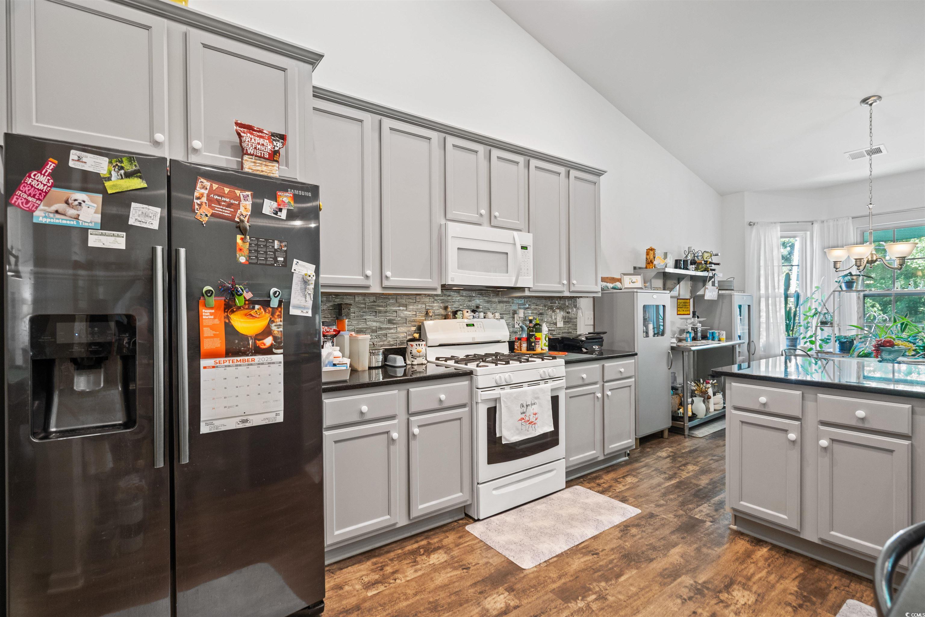 826 Cypress Way Little River, SC 29566 - Photo 17 of 40 Kitchen featuring gray cabinetry, dark countertops, white appliances, decorative backsplash, and pendant lighting