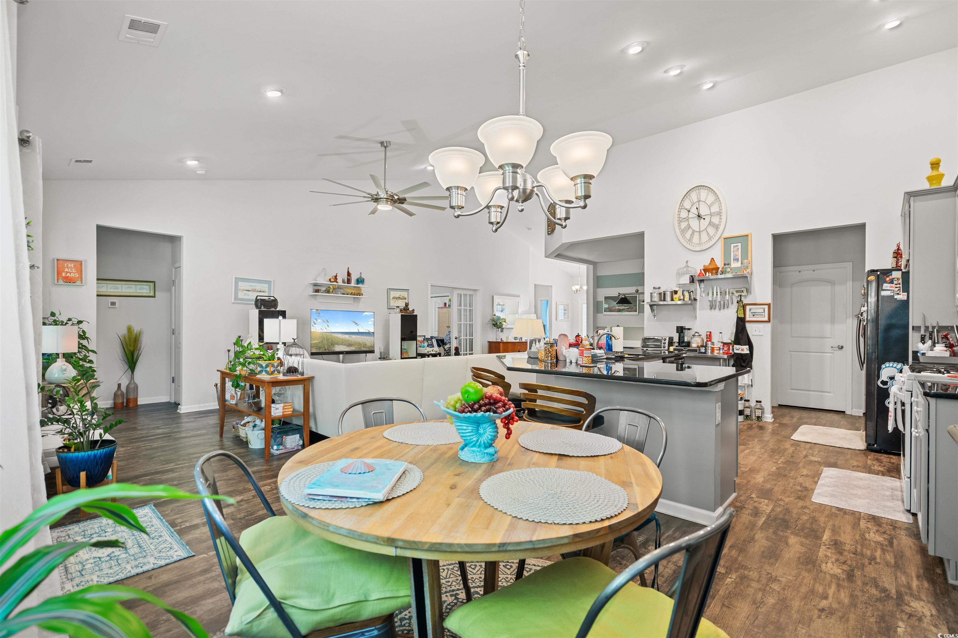 826 Cypress Way Little River, SC 29566 - Photo 19 of 40 Dining room with dark wood-style floors, a chandelier, high vaulted ceiling, and recessed lighting